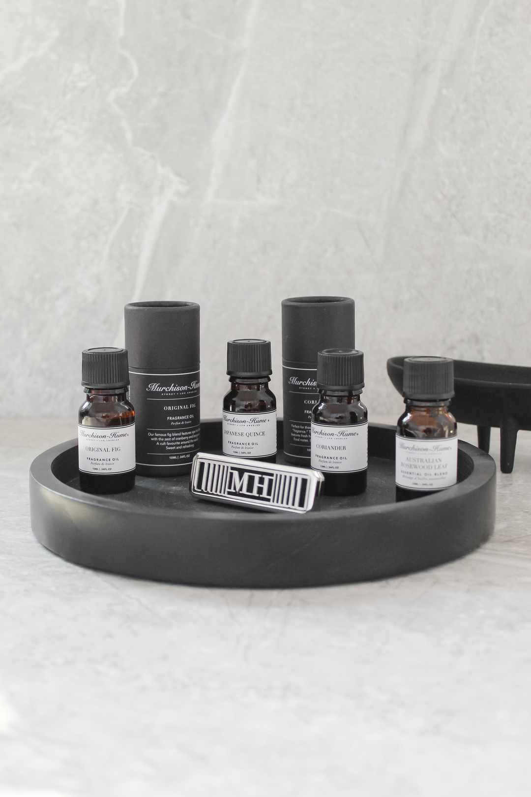 assorted fragrance oil with diffuser on black soapstone tray